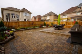 backyard interlocking project with flower beds